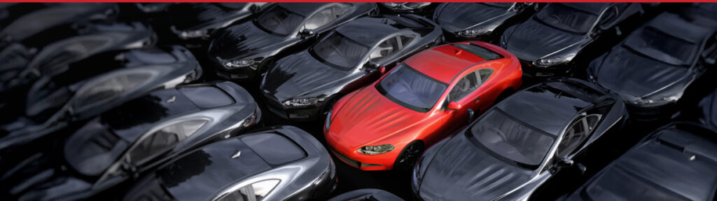 row of parked cars with a single red vehicle in focus, symbolizing high-mileage inventory and rising reinsurance risk in Florida dealerships.