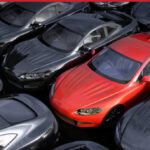 row of parked cars with a single red vehicle in focus, symbolizing high-mileage inventory and rising reinsurance risk in Florida dealerships.